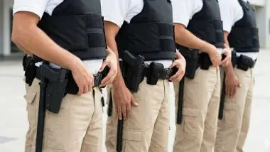 Guardias Armados alineados con las manos en el uniforme, mostrando una postura firme y de vigilancia.